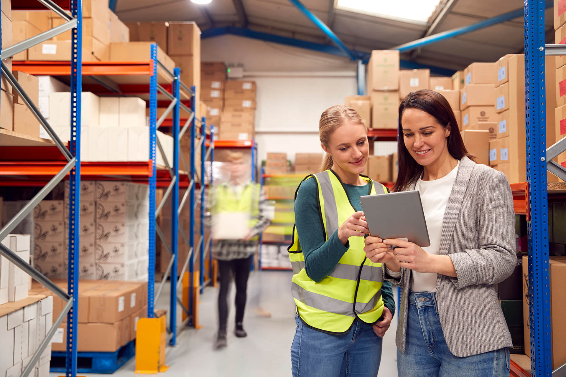 manager using digital tablet with female intern