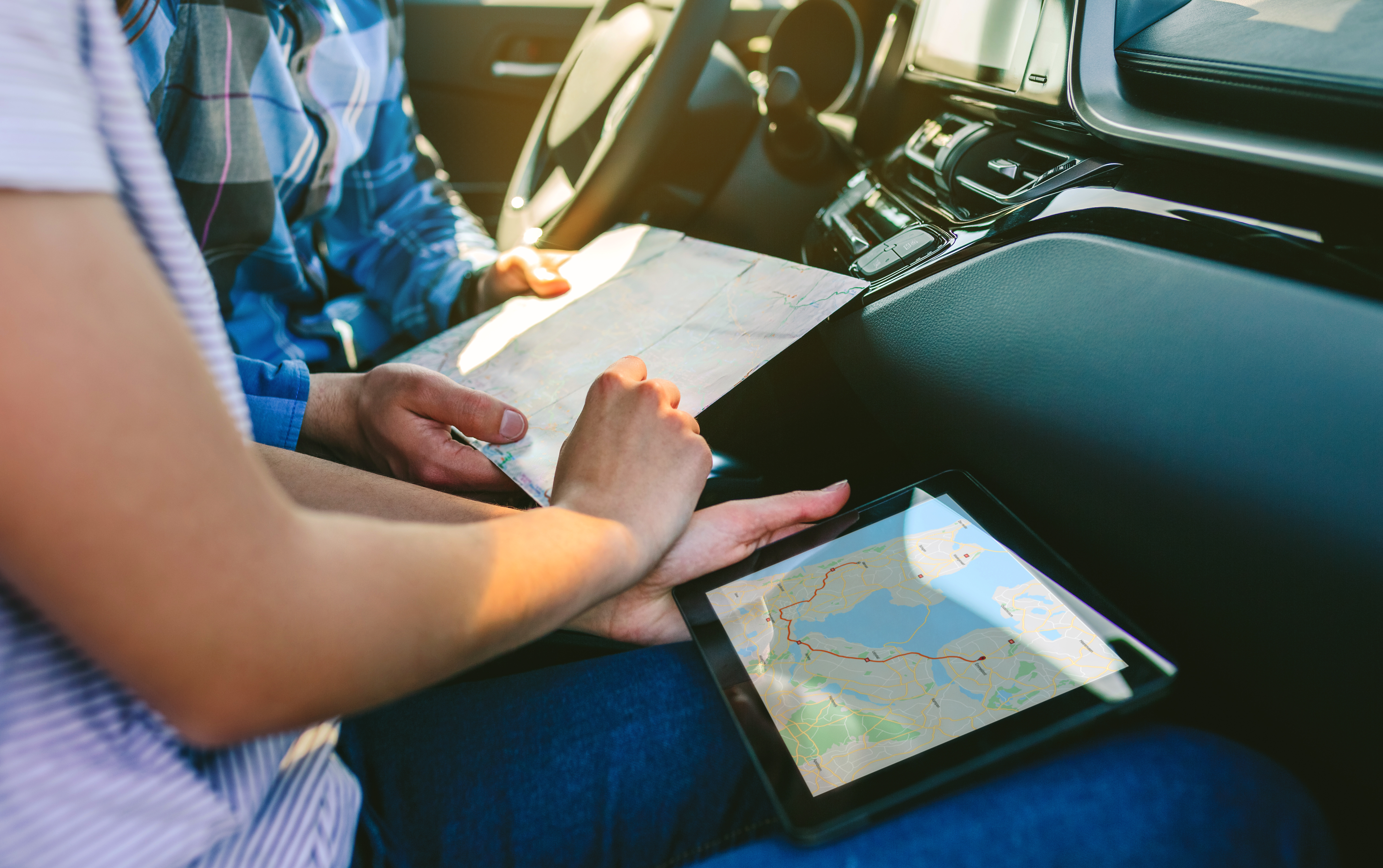 two people comparing paper maps to digital maps